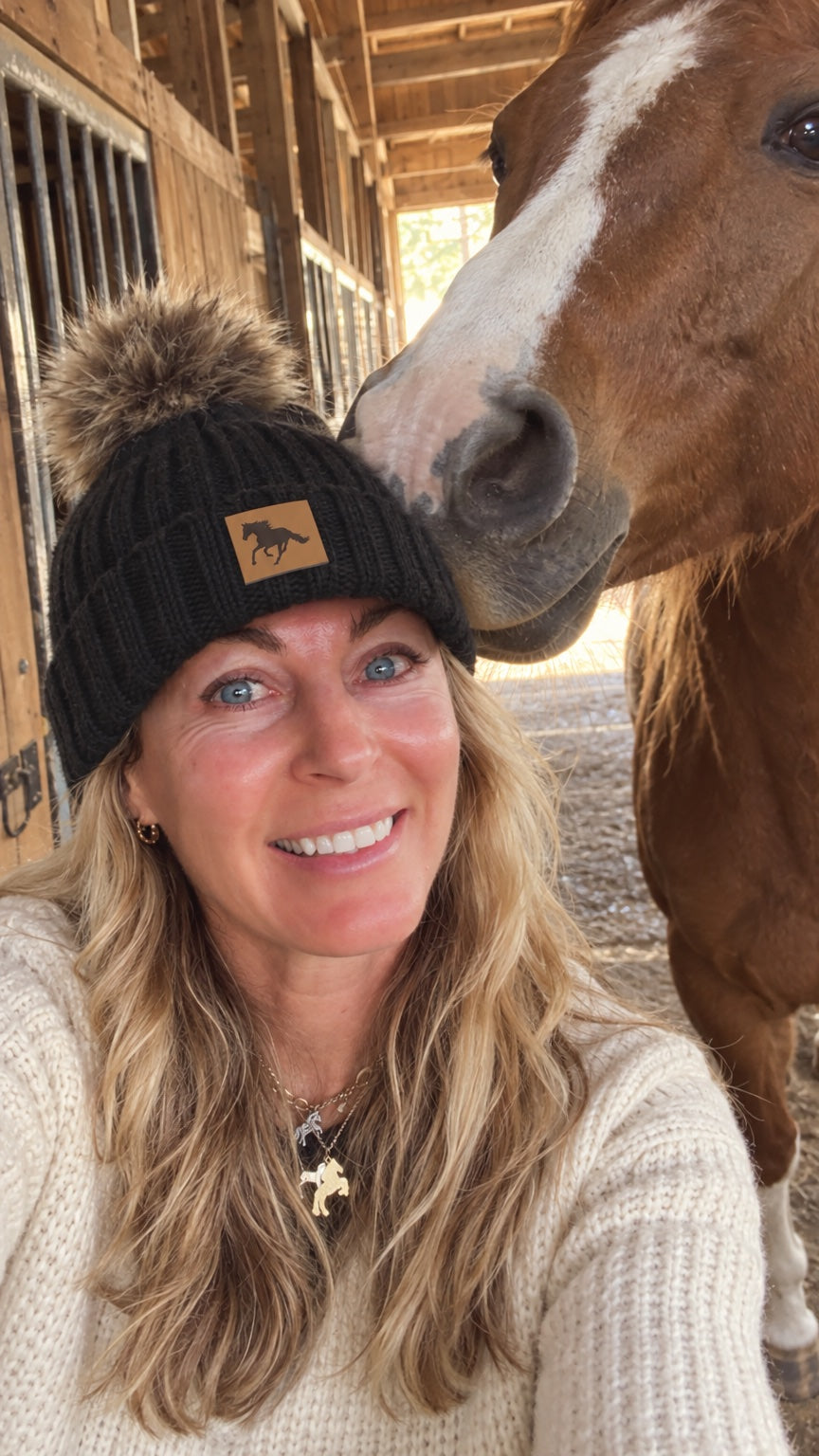 Tahlia selfie in the beanie with a chestnut horse nuzzling her